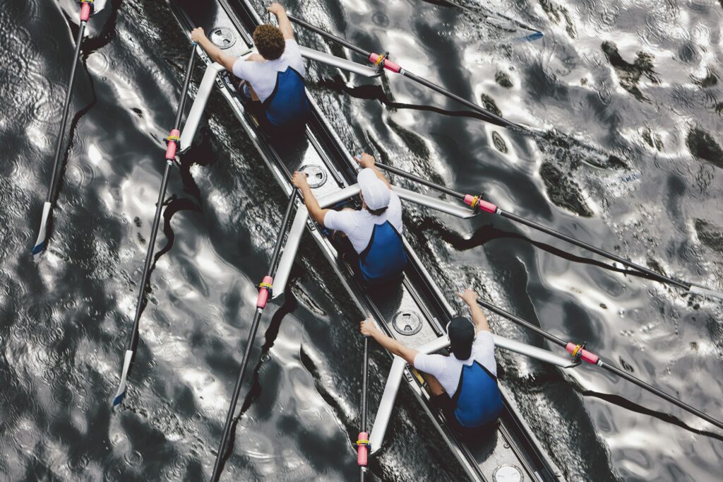 Overhead view of a crew rowing in an octuple racing shell boat, rowers, motion blur.