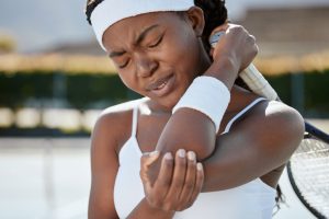 Black woman, tennis and elbow pain from injury, fitness or outdoor athlete in medical emergency or