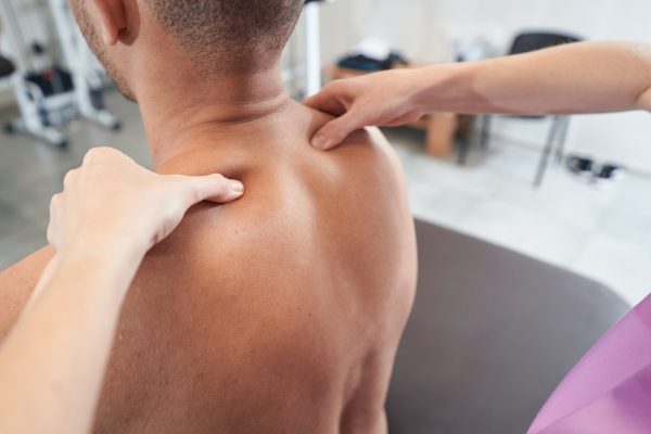 Man reconceiving massage treatment in physiotherapy clinic